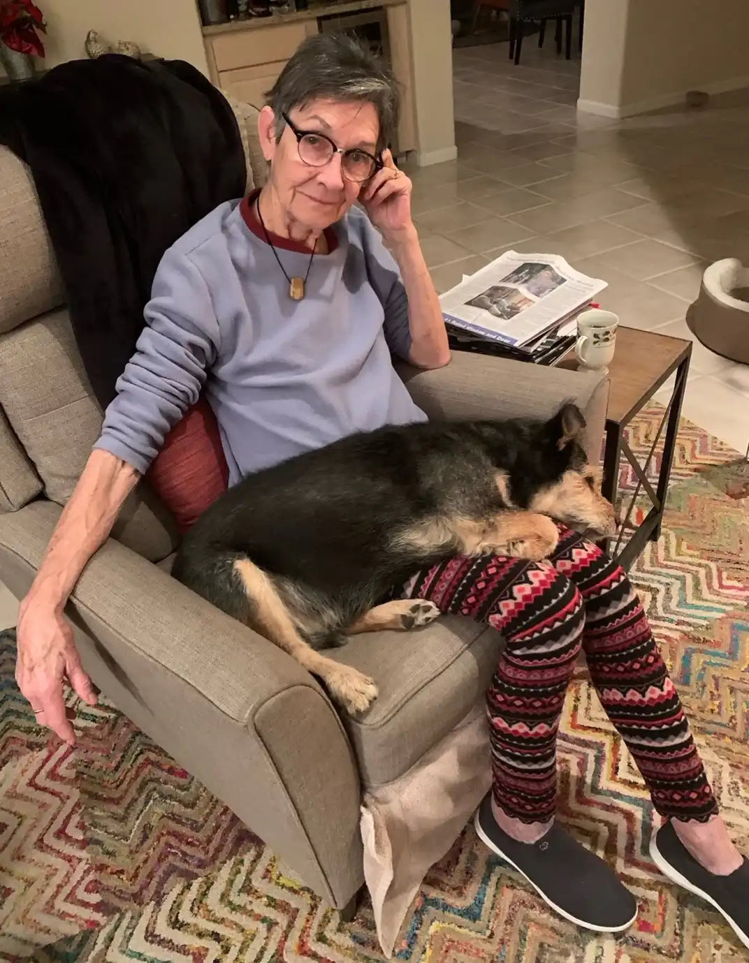 mama becker sitting in armchair with senior dog on lap